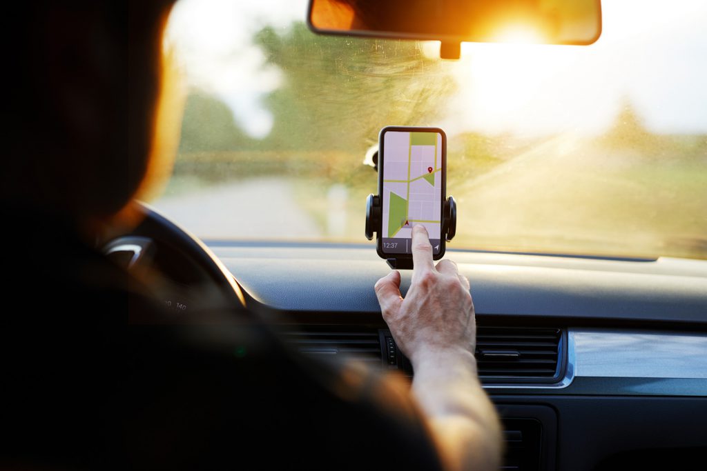 Driver uses navigation on his mobile phone in the car